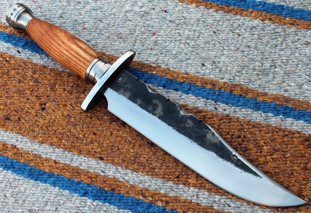 Sehr schönes klassisches Bowie Messer mit einem symmetrischen Griff aus Eschenholz. Die Klinge ist 200 mm lang, 40 mm breit und 5,3 mm stark,  Parierelement aus Klingenstahl, Zwinge und Knauf aus rostfreiem Stahl.  Das Messer liegt gut und wendig in der Hand, ein echter Fighter. ---Nr. H 074---