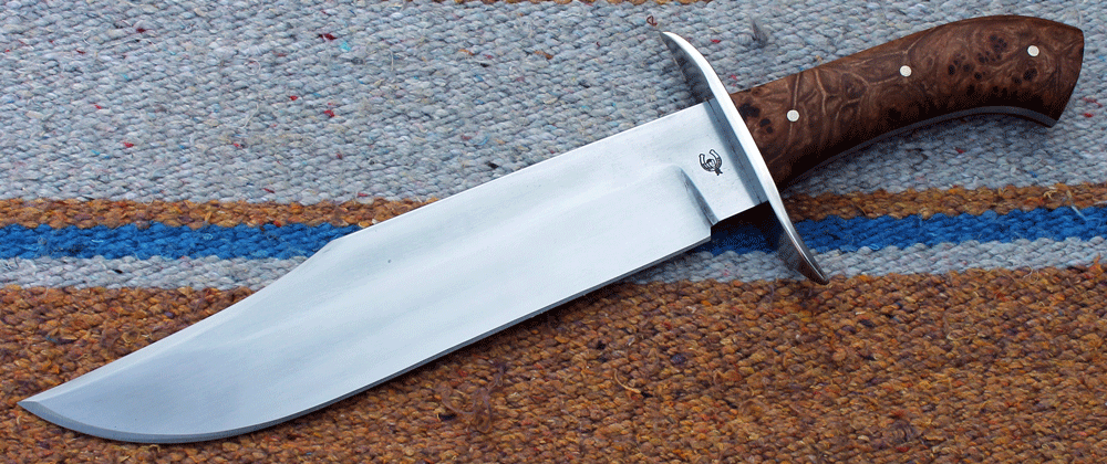großes und schweres Bowie Messer vom Typ: "DAS ... ist ein Messer!"  Die Klinge aus bestem Carbon Klingenstahl ist satte 250 mm lang, 50 mm breit und 6,4 mm stark, angelassen auf 60 Rockwell.  Parierelement aus Edelstahl, Griffschalen auf der durchgehenden Blattangel aus  stabilisiertem Ulme-Maserholz. ---Nr. K 037--- 